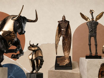Editorial collage of Korkut Sönmez’s bronze sculptures, including a rhinoceros, cicada and abstract winged forms, arranged on stone plinths against a textured neutral background.