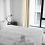 Neatly made bed in a bright guest bedroom