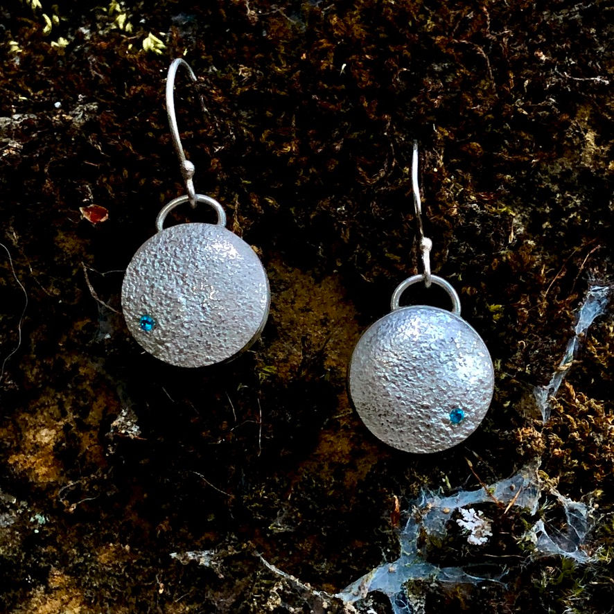Thumbnail: Lunar Moon Drop Silver Earrings with Blue Topaz on Mossy Background by Flying Silver Studio
