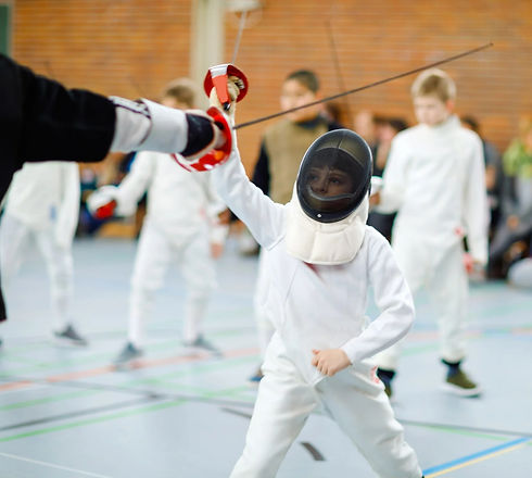 Young fencer parrying and going to hit his fencing coach.