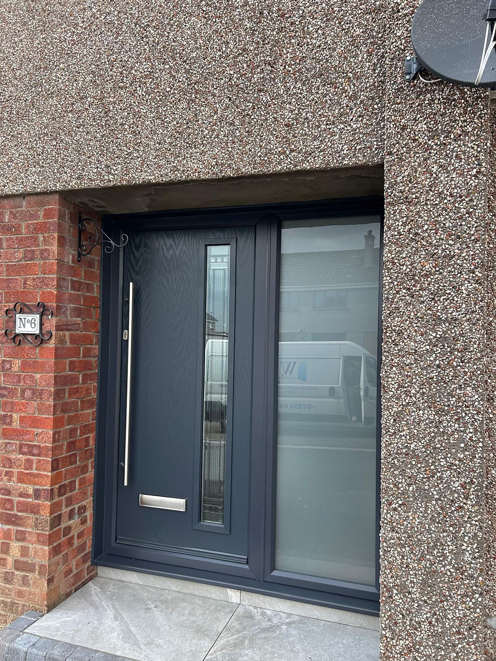 A black front door with glass panels, partially installed, tools and a drill on the floor nearby.
