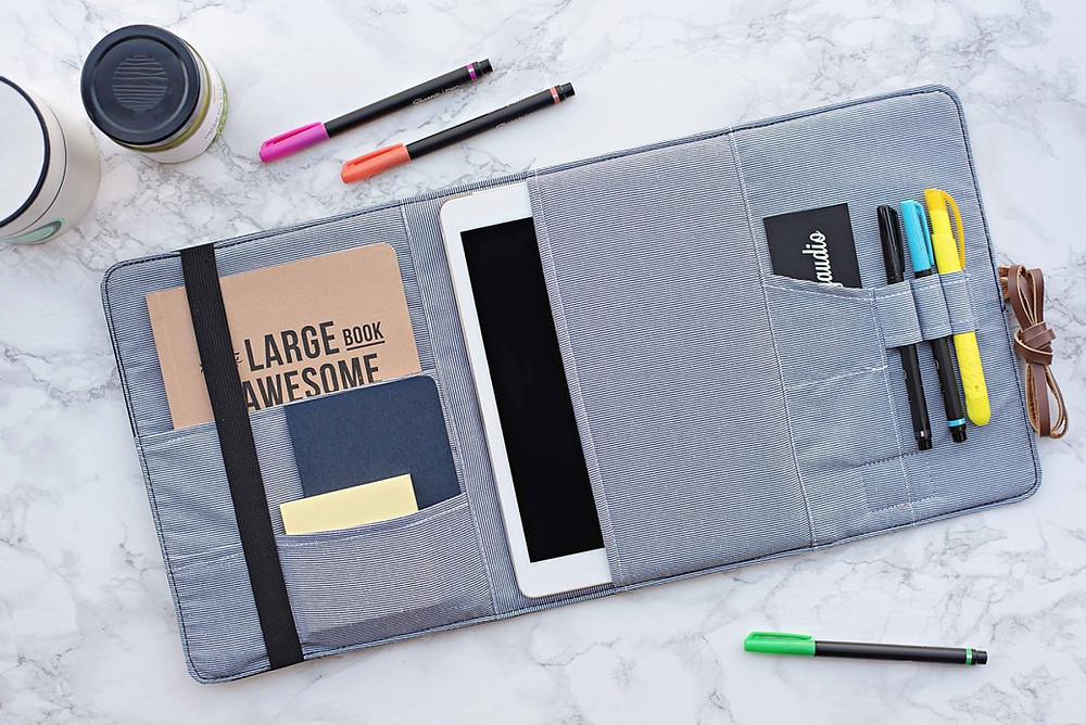 open organizer with notebooks, tablet, pens, and business cards inside