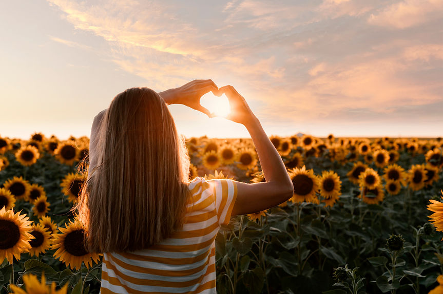 back-view-woman-making-heart-shaped-hands-sunset.jpg