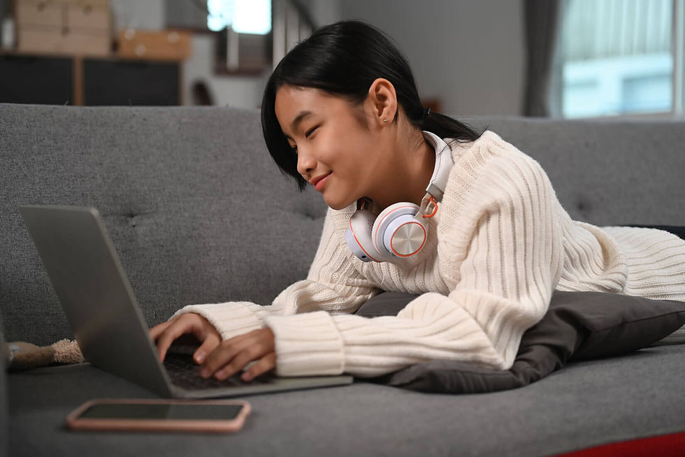 young-asian-girl-lying-on-sofa-and-using-laptop-co-Q5YHTHY-1.jpg