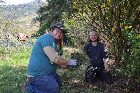 Two people pose with a handful of invasive plants.