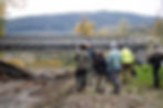 People gather in front of a bridge.