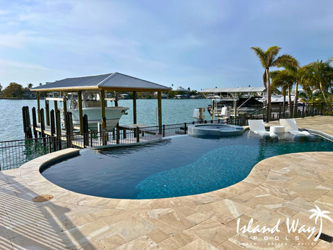 Infinity Edge Pool With A Spillover Spa, Sunshelf, & Travertine Decking In Clearwater Beach