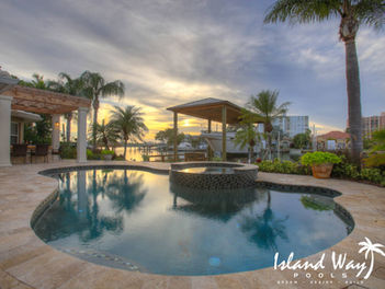 Waterfront Freeform Pool With Travertine Decking And A Spillover Spa