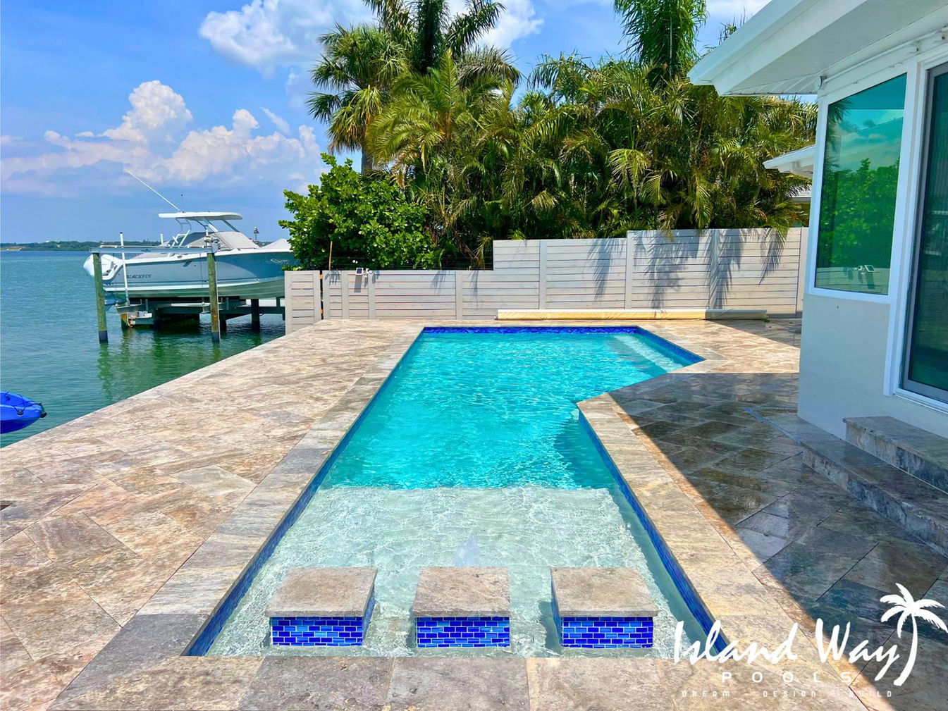 Geometric Pool Featuring Floating Steps, A Sunshelf, and Travertine Decking In St. Petersburg