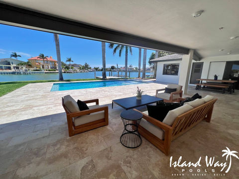Linear, Waterfront Pool Featuring Travertine Decking In Pinellas County