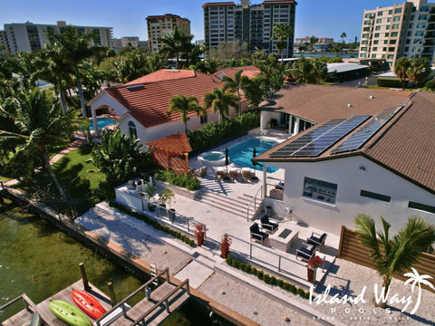 Watefront Outdoor Living Space With A Fire Table, Outdoor Kitchen, Pergola, & Pool In Clearwater Beach