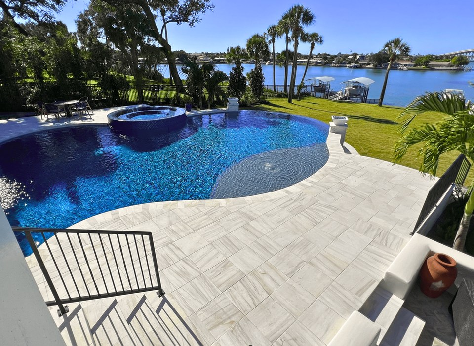 Freeform infinity edge pool with a sunshelf and 360 spillover spa in pinellas county