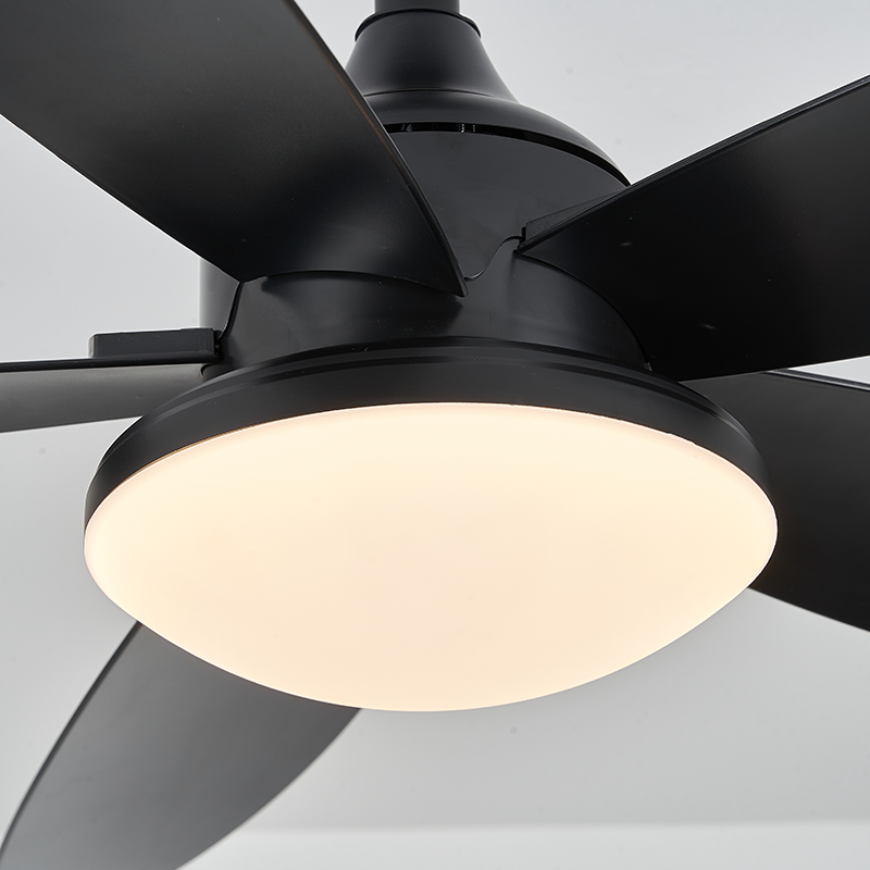 Close-up of a black fan light, showing its illuminated round diffuser, motor housing and curved ABS blade connections.