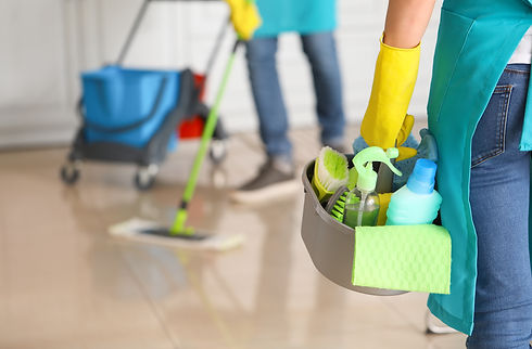 Female janitor with cleaning supplies in