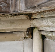 A stone cornice in need of a repair using traditional lime mortars by a skilled stonemason