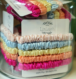 A glass container filled with satin scrunchies 