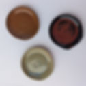 A topdown view of three spoon rests, orange, red and green variations.