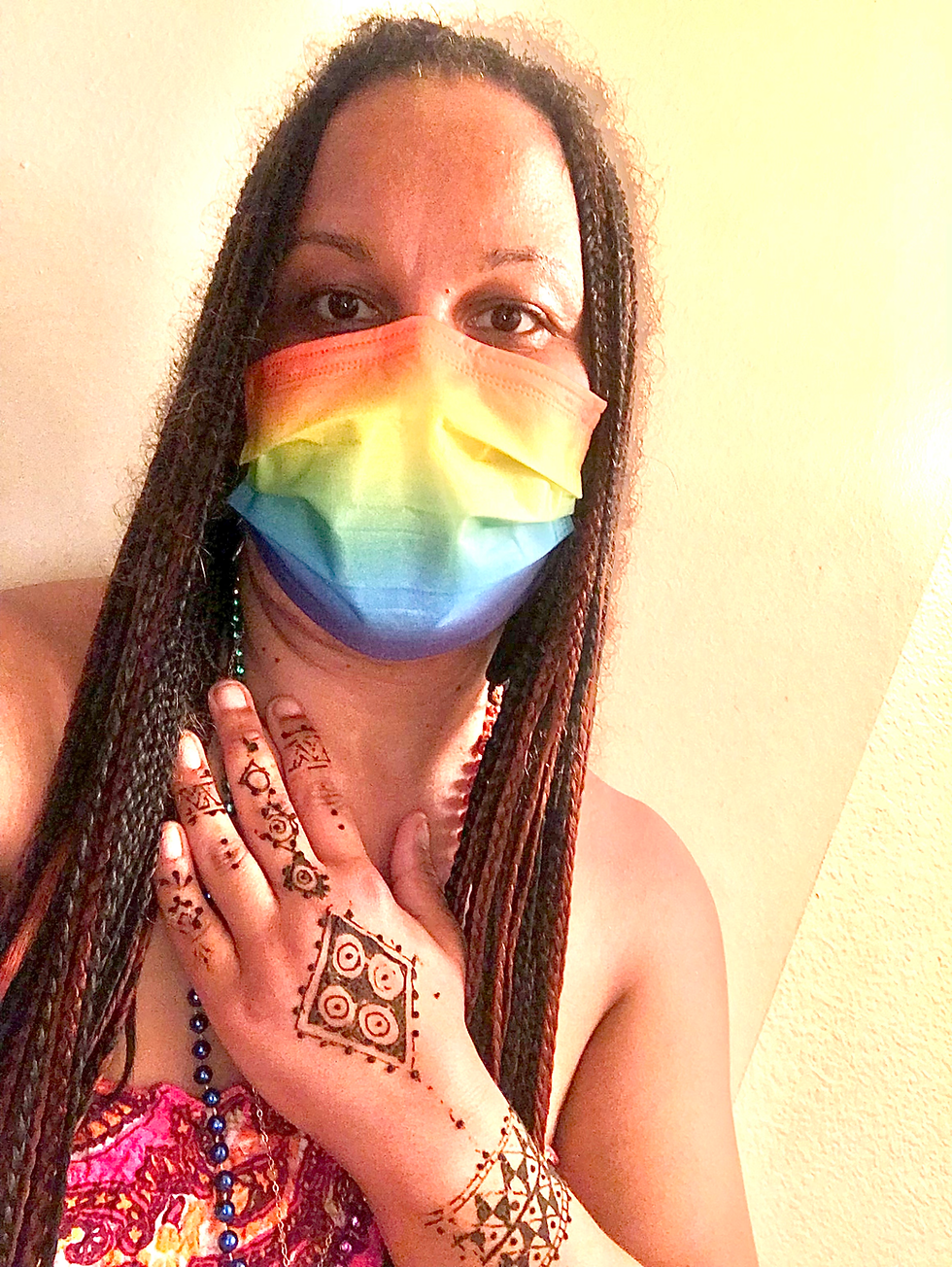 Allison Coleman celebrating Pride Month while traveling, smiling outdoors with rainbow colors and Dream Worldtrotter spirit