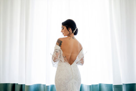 Fine-art bridal portrait of a bride from behind, showing her wedding dress and veil on a panoramic balcony in Ravello with the Amalfi Coast landscape.