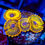 Thumbnail: Vibrant LC Soprano 2.0 Zoanthid coral close-up, showing its bright golden-yellow coloration and dark speckles, on a frag plug