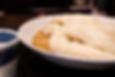 A bowl of Inaniwa udon with thin, smooth noodles served with dipping sauce.