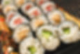 A rolled sushi with rice and various fillings wrapped in seaweed.