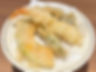 A plate of tempura featuring golden-brown battered and deep-fried seafood and vegetables.