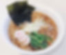 A bowl of Shoyu ramen with soy sauce-based broth, noodles, and toppings like seaweeds and green onions.