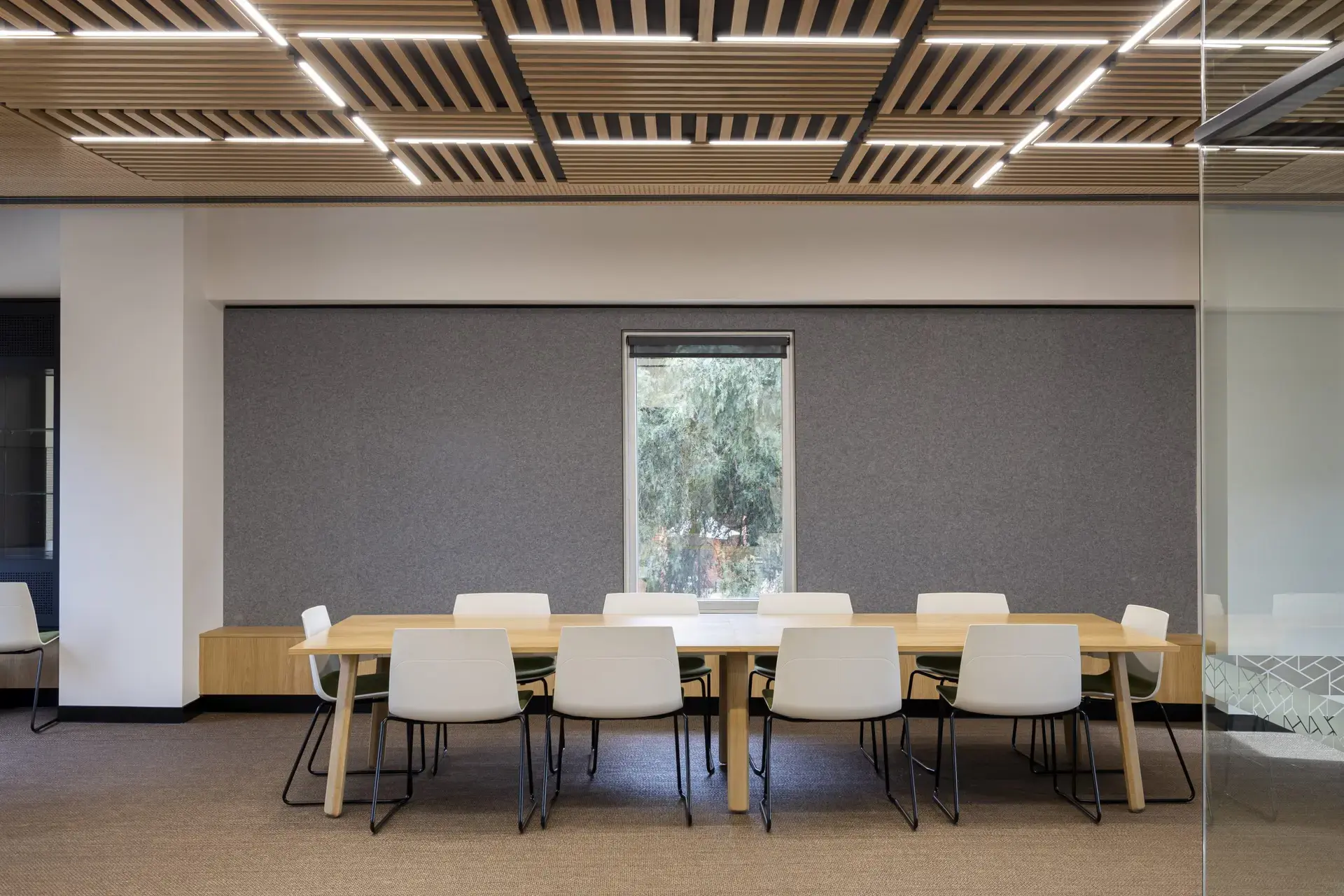 Commercial boardroom featuring BACH Commercial’s full-wall grey acoustic panels for sound absorption.