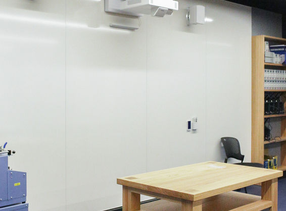 STEM learning space featuring a floor-to-ceiling WriteWall® whiteboard system by BACH Commercial, integrated with ceiling-mounted projectors and AV tools.