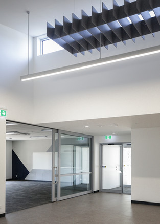 Suspended acoustic ceiling baffle and glass door entryway at Beaconhills College Pakenham, enhancing acoustic comfort near flexible learning spaces.