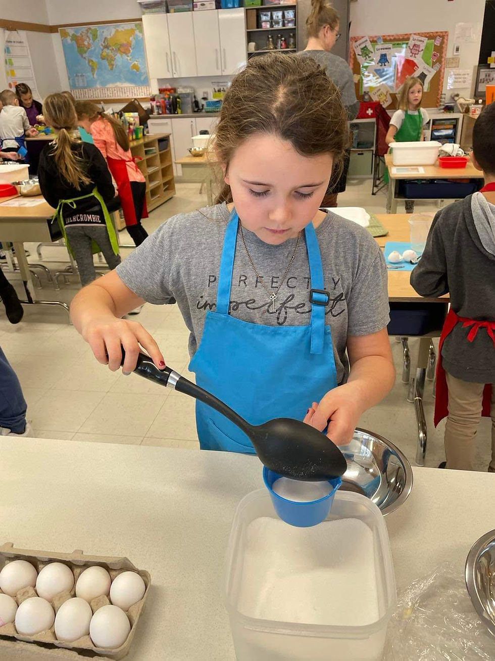 Jeune fille qui prend du sucre avec une spatule pour mettre dans une tasse à mesurer