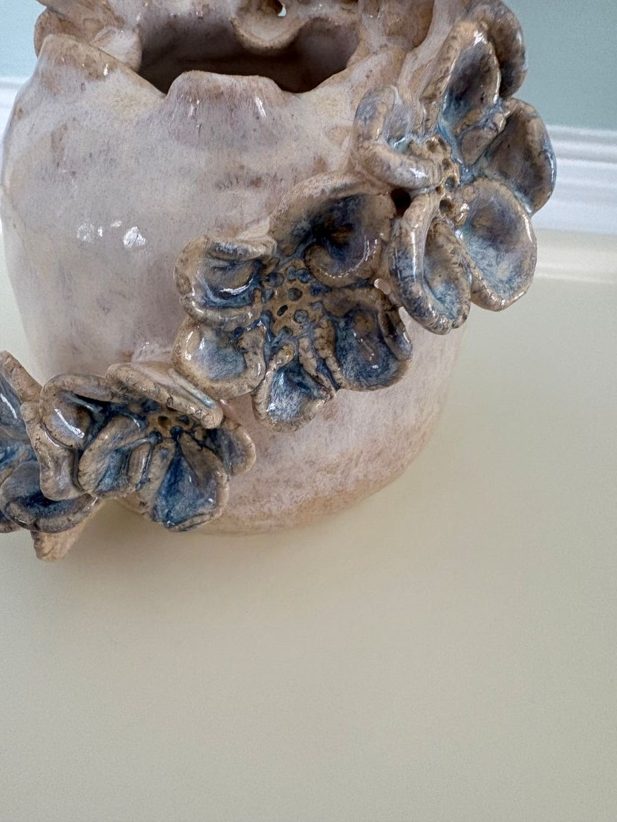 Thumbnail: Closeup of a White and Blue Round Ceramic Vase with organic shaped handmade flowers