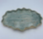Oval ceramic platter with wavy edges, featuring a speckled turquoise glaze.