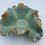 Thumbnail: A ruffled ceramic bowl with a glossy turquoise and earthy brown glaze sits on a plain white background