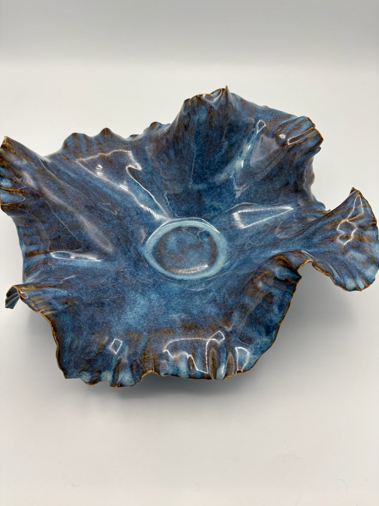 Handbuilt cobalt and violet stoneware bowl with sculptural ruffled edges and iridescent glazed ceramic surface.