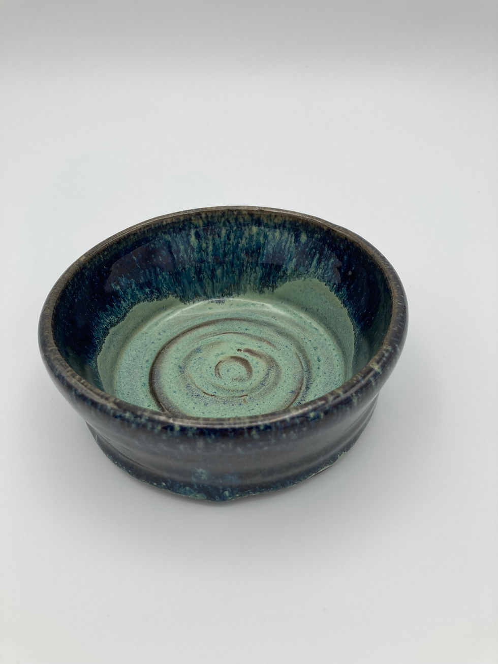 Thumbnail: Blue-green ceramic bowl with a spiral pattern inside, set against a plain white background. The glaze is glossy and textured.