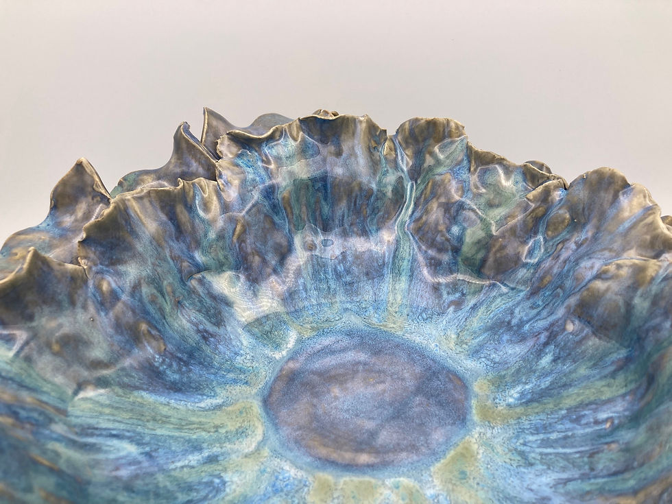 Thumbnail: Close up of Ruffled blue ceramic bowls with layered design on a white background, resembling ocean waves.