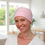 Thumbnail: A lady wearing a pretty pink chemo headwear for women with hair loss