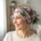 A woman wearing a pink cancer headscarf for hairloss and smiling