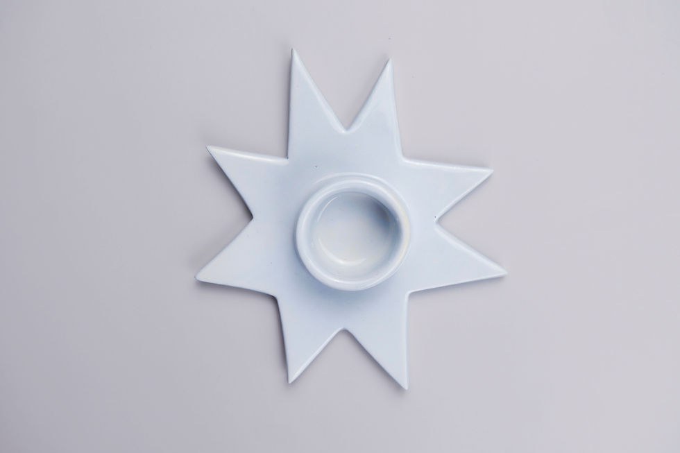 Portavelas FAUNA_Baby blue en forma de estrella sobre una superficie gris. Ohdella!