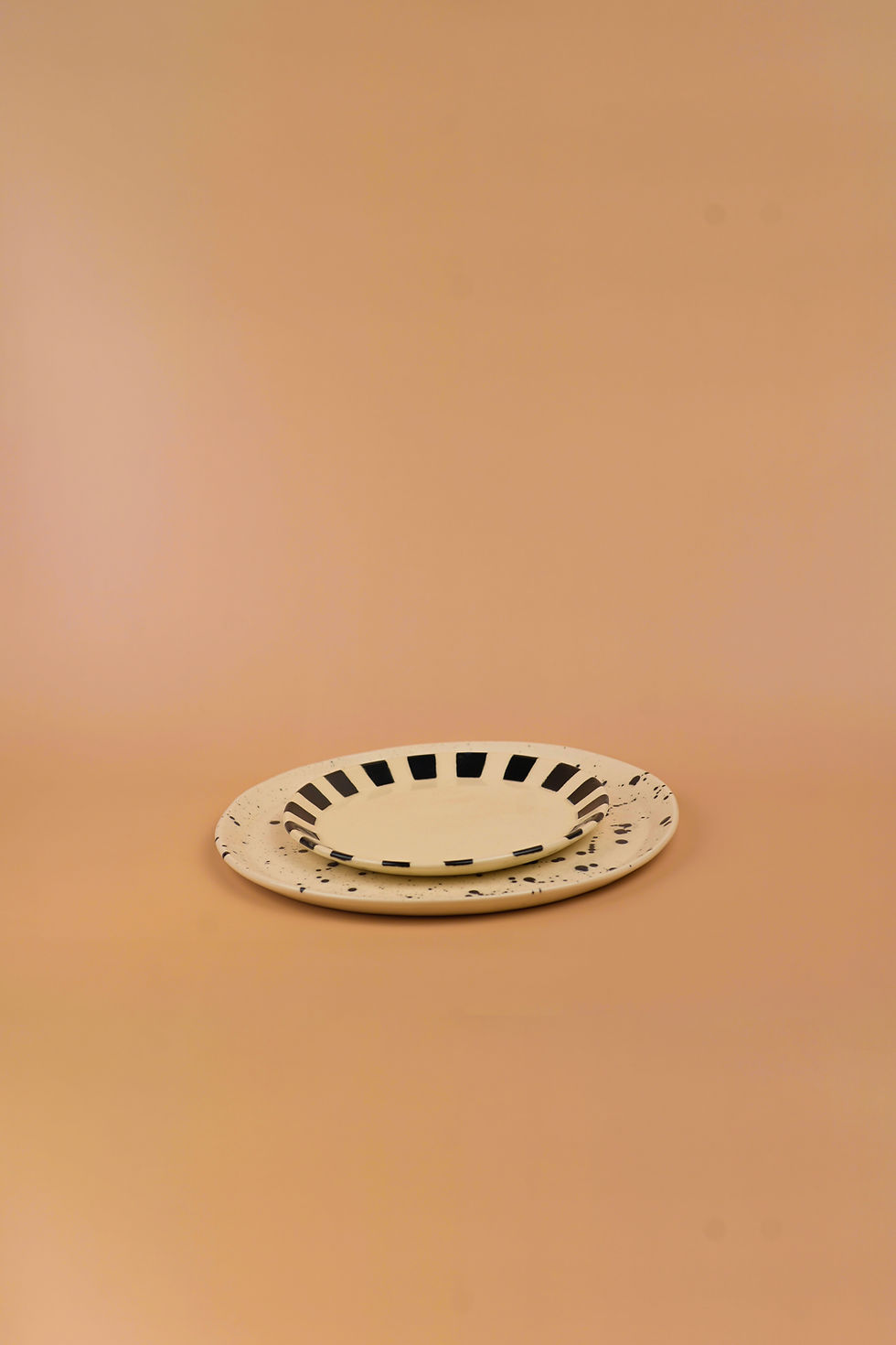 Platos blancos con líneas negras sobre un fondo beige. Ohdella!