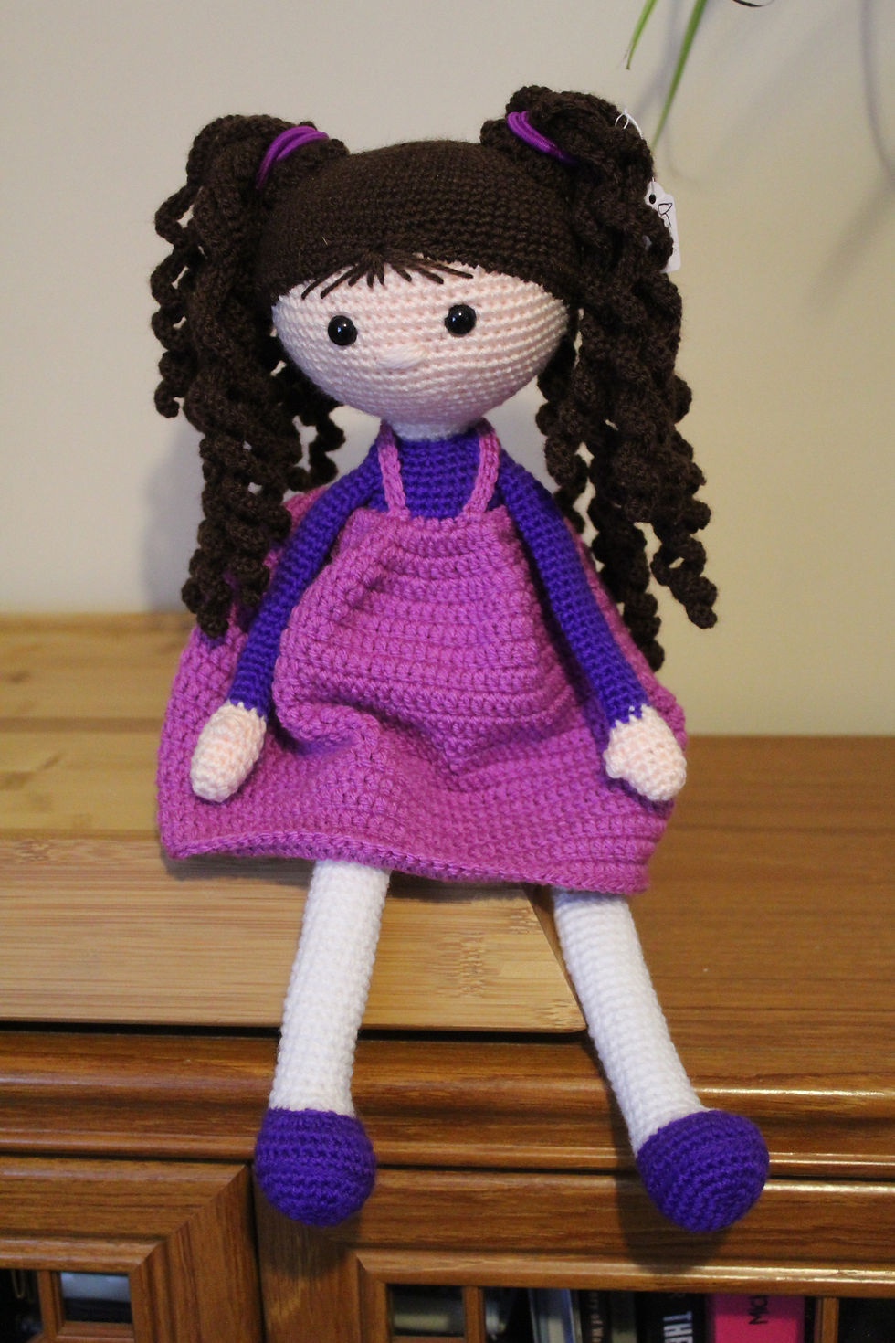 Handmade crochet doll with long pigtails.