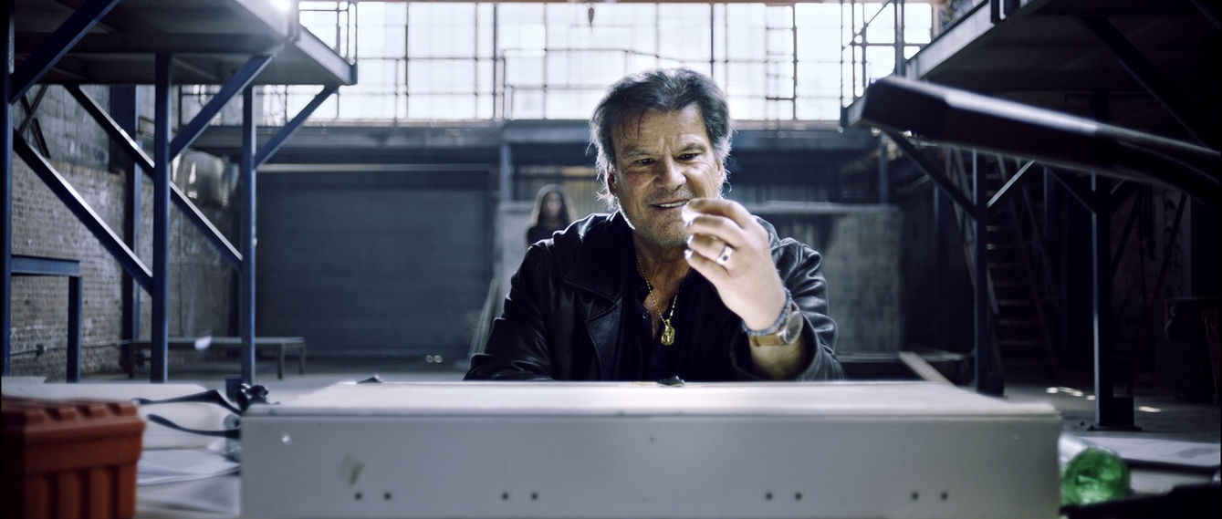 Jerome R Marzullo studying a crystal on an illuminated table. crime thriller investigation scene, Deep Chicago music video