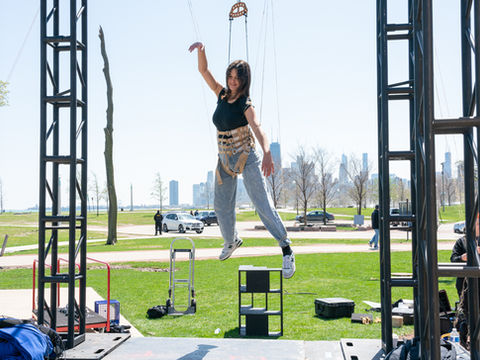 Actress suspended above puppet stage during rehearsal.