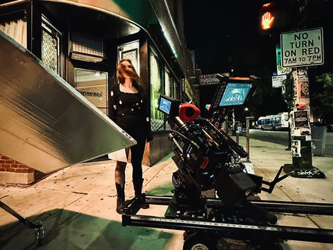 Cinema camera on a dolly positioned on a city street at night.