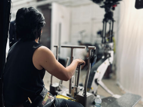 Andy Cat seated on a camera dolly platform controlling movement while the ARRI Alexa 35 camera is mounted ahead.