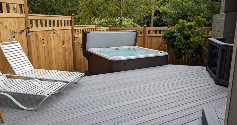 Beautiful custom backyard builds by Decks and Spas featuring deck and hot tub, privacy screen, BBQ centers, and firepits. Composite decking. Located in Redmond, Serving the Eastside, and Greater Seattle.