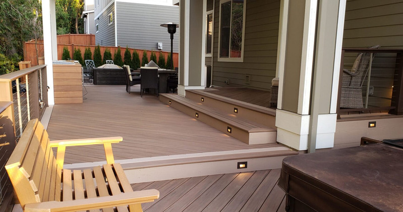 Beautiful custom backyard builds by Decks and Spas featuring deck and hot tub, privacy screen, BBQ centers, and firepits. Composite decking. Located in Redmond, Serving the Eastside, and Greater Seattle.