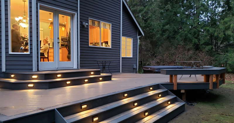 Beautiful custom backyard builds by Decks and Spas featuring deck and hot tub, privacy screen, BBQ centers, and firepits. Composite decking. Located in Redmond, Serving the Eastside, and Greater Seattle.